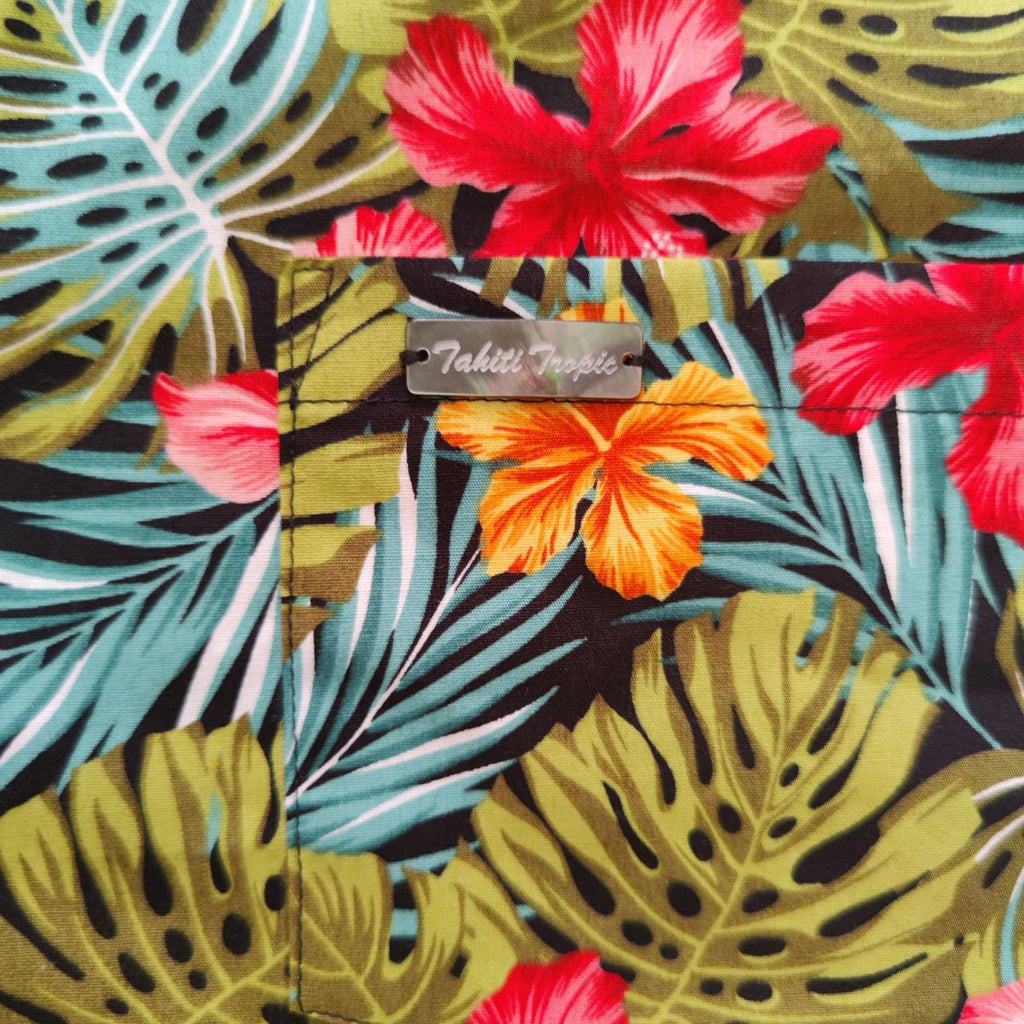 Chemise tahitienne hibiscus rose et orange sur fond noir. Chemise en coton manches courtes, détail logo, tissu tahitien et boutons en nacre. Edition limitée