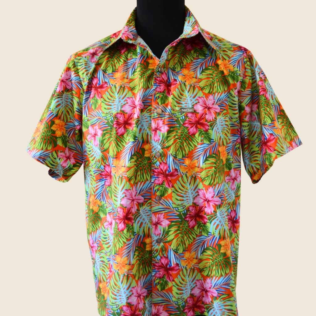 Chemise tahitienne hibiscus rose et orange sur fond orange. Chemise en coton manches courtes, tissu tahitien et boutons en nacre. Edition limitée